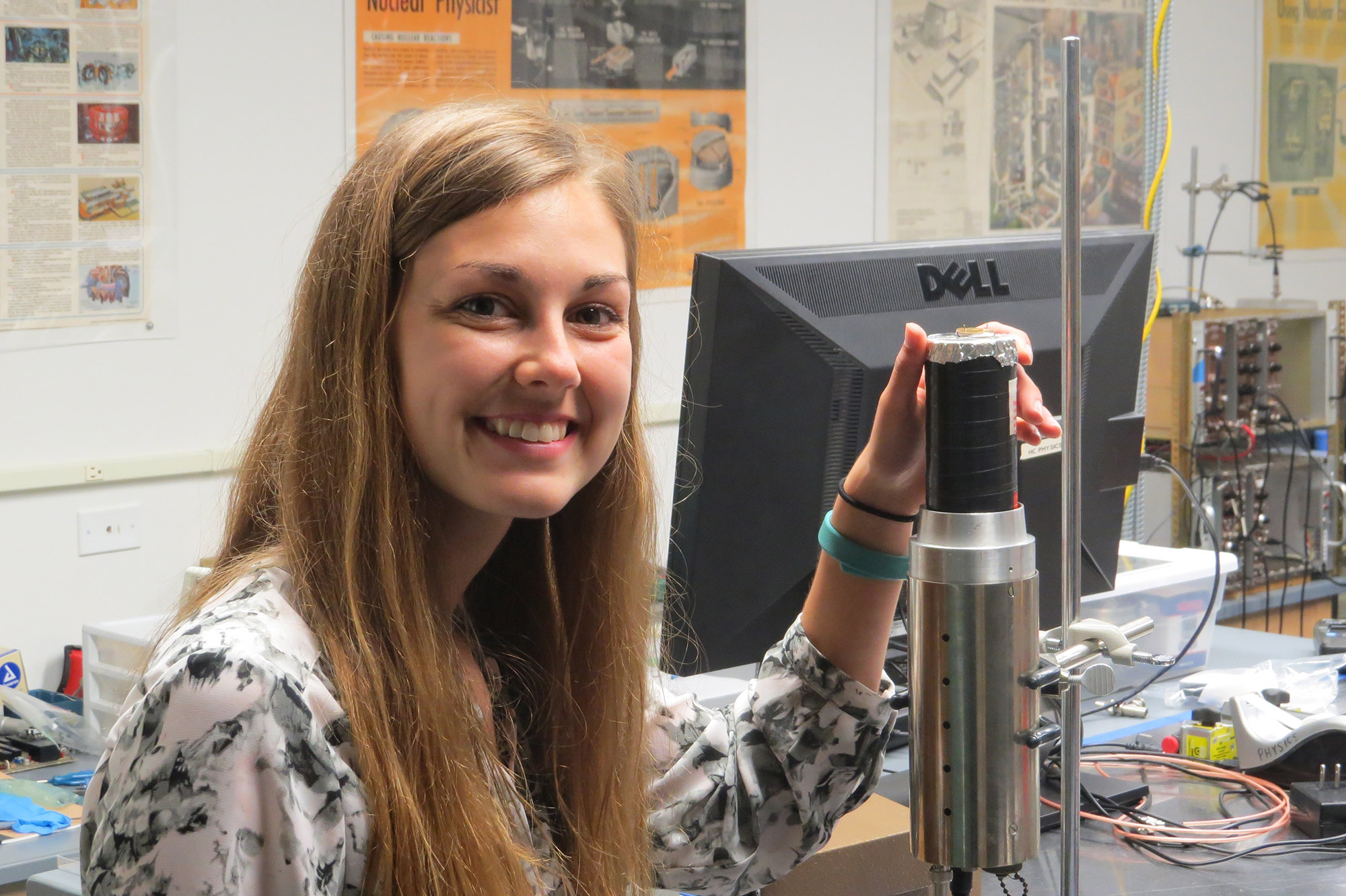 Katelyn Cook standing next to a scientific instrument.
