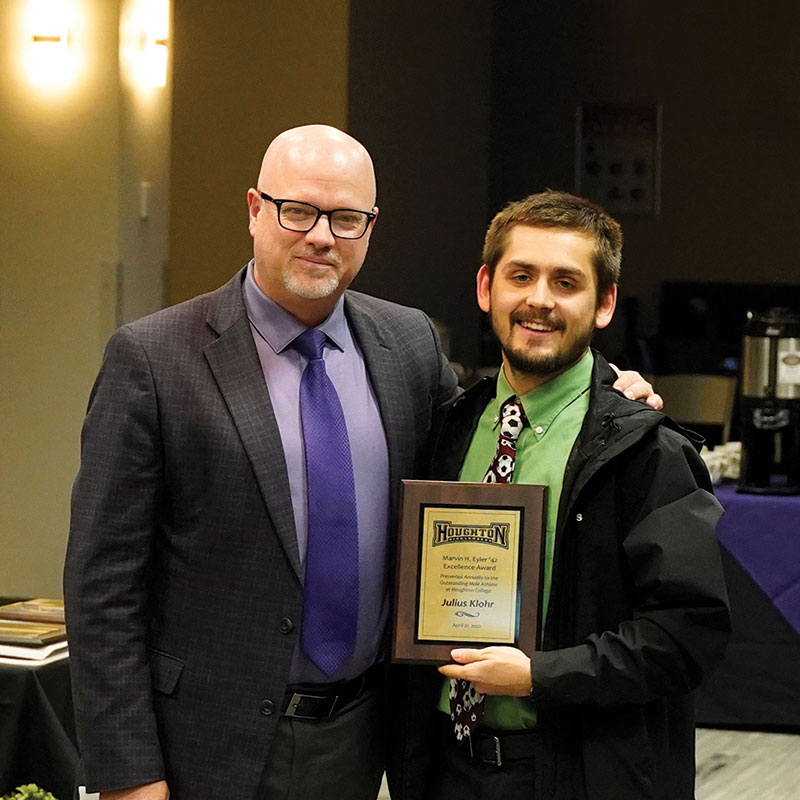Houghton student Julius Klohr holding award standing with Matthew Webb.