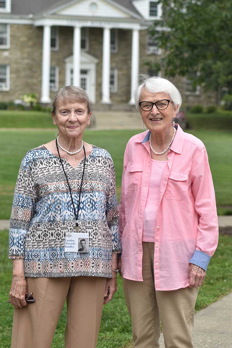 Two Houghton alumni standing on the campus lawn during the summer alumni reunion.
