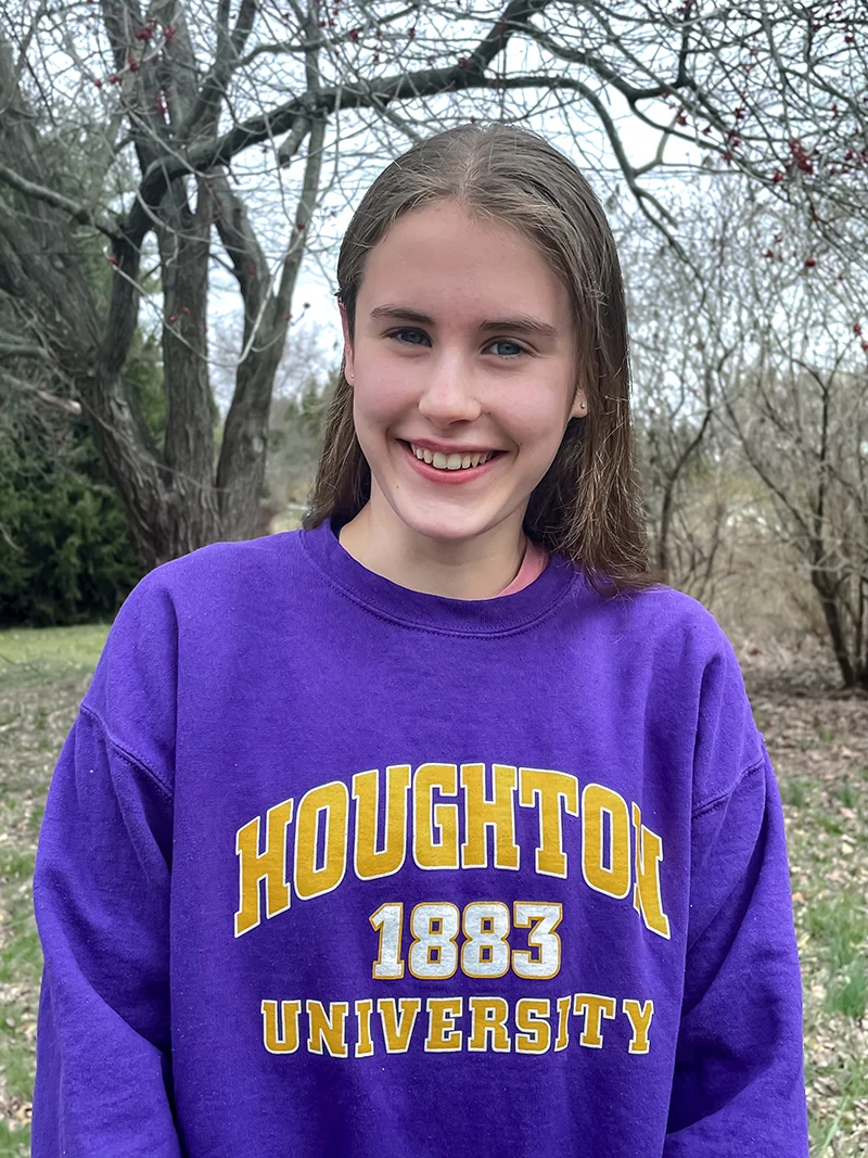Carolyn Powers wearing a Houghton sweatshirt and smiling.